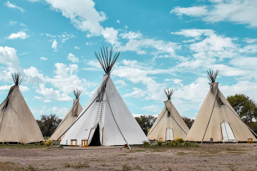 Cinq tentes tipi sur une surface boueuse