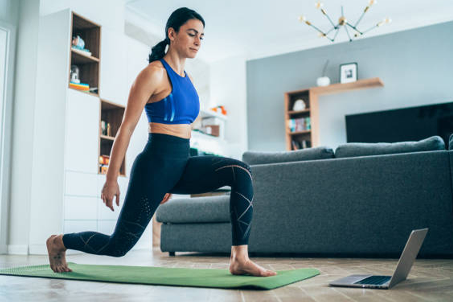 Frau trainiert zu Hause mit Leggings mit hoher Taille