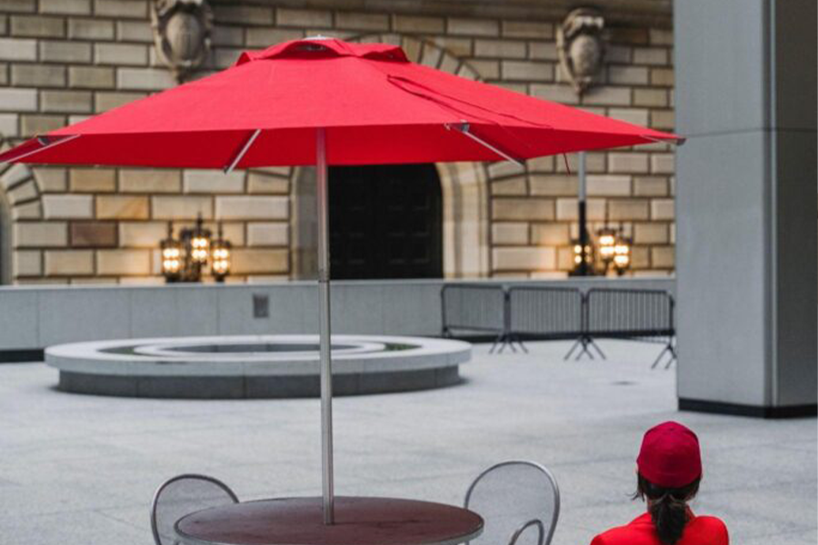 A red tiered umbrella in front of a diplomatic building