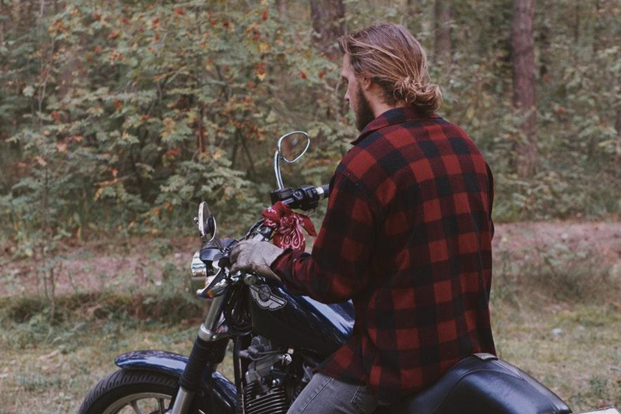 Homem em uma bicicleta com uma camisa de manga longa blindada