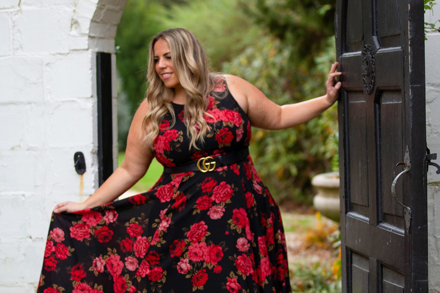 Senhora de tamanho grande em vestido de festa de jardim vermelho e preto