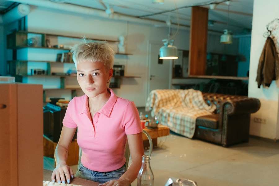 Signora dai capelli biondi in polo rosa con blue jeans