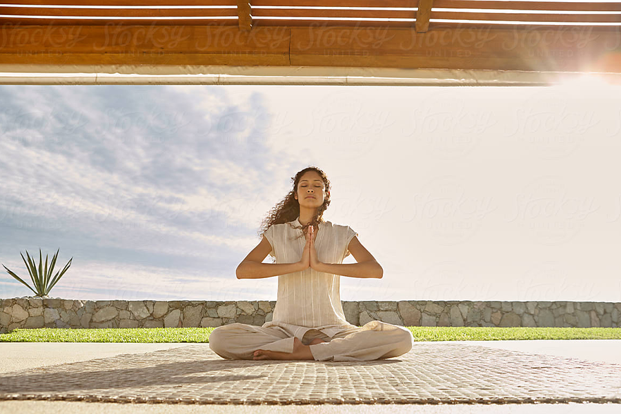 Parlayan tozlukla oturmuş yoga pozu veren kadın