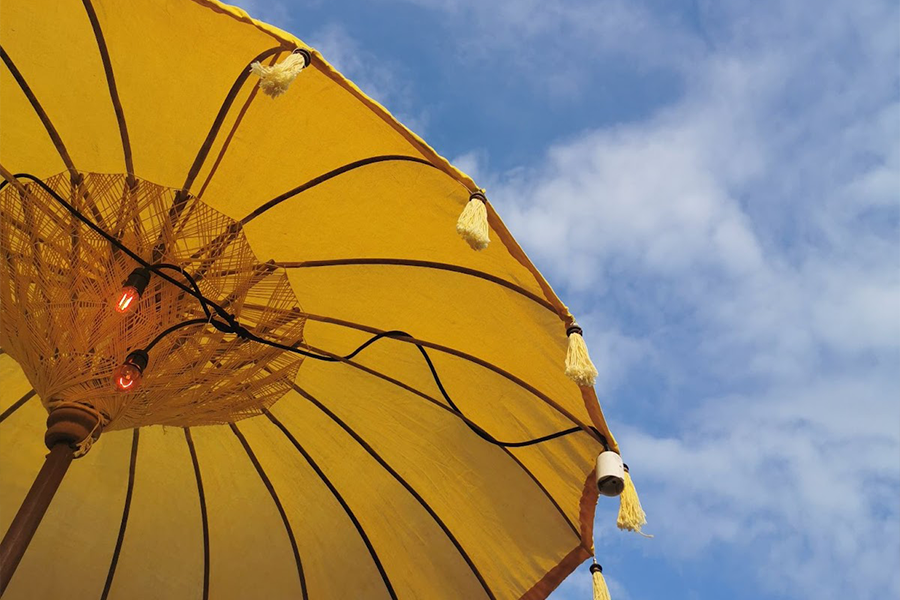 A patio umbrella with light bulbs ready for the night