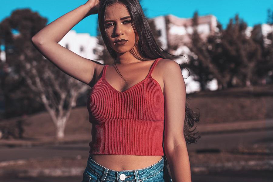 Uma mulher em um top vermelho sobre um jeans