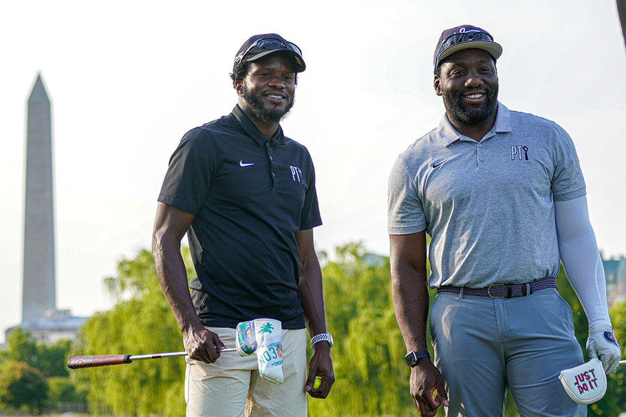 Deux hommes souriants portant des chapeaux et des t-shirts de polo