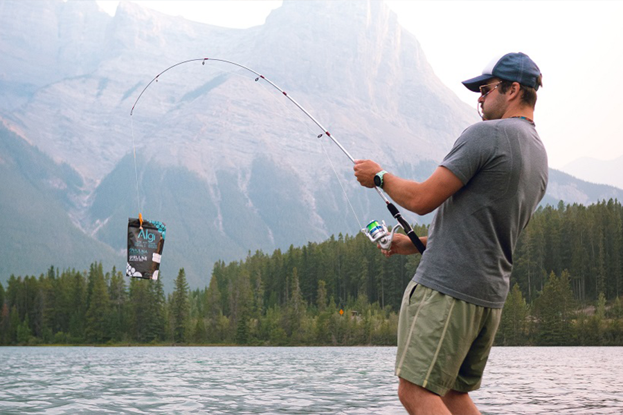 Angler em calções de pesca cinzentos e uma t-shirt de camada de base