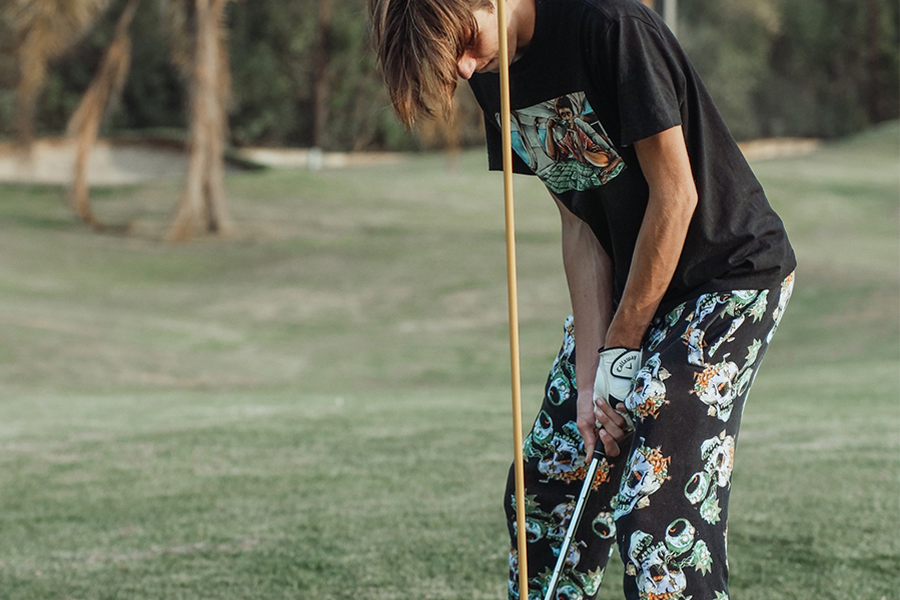 Joven con camiseta negra con eslogan y pantalones con estampado de diseño