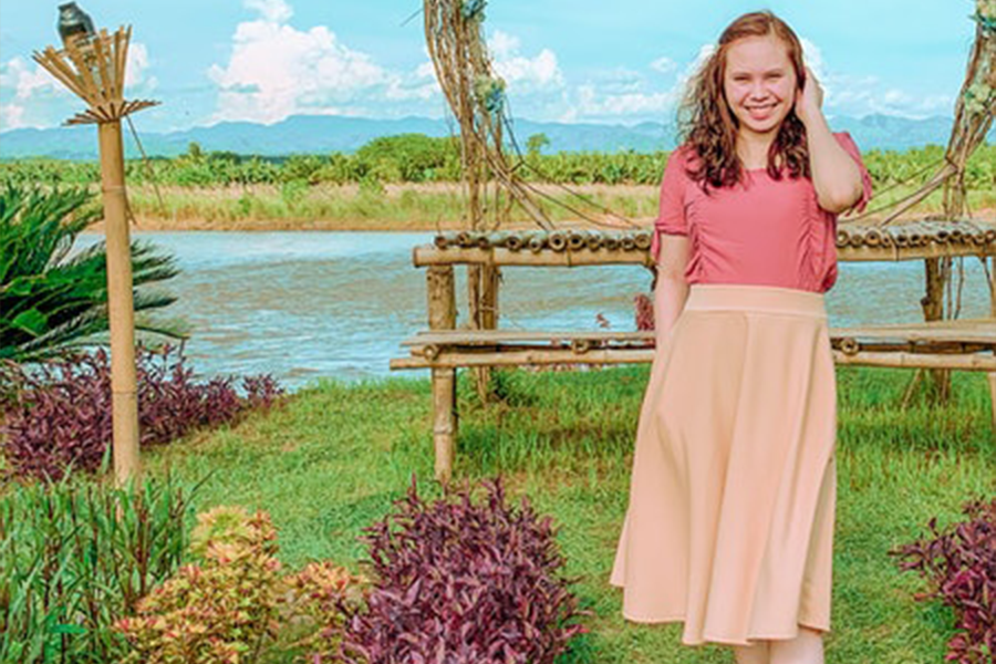 A woman wearing a pink midi skirt and pink top