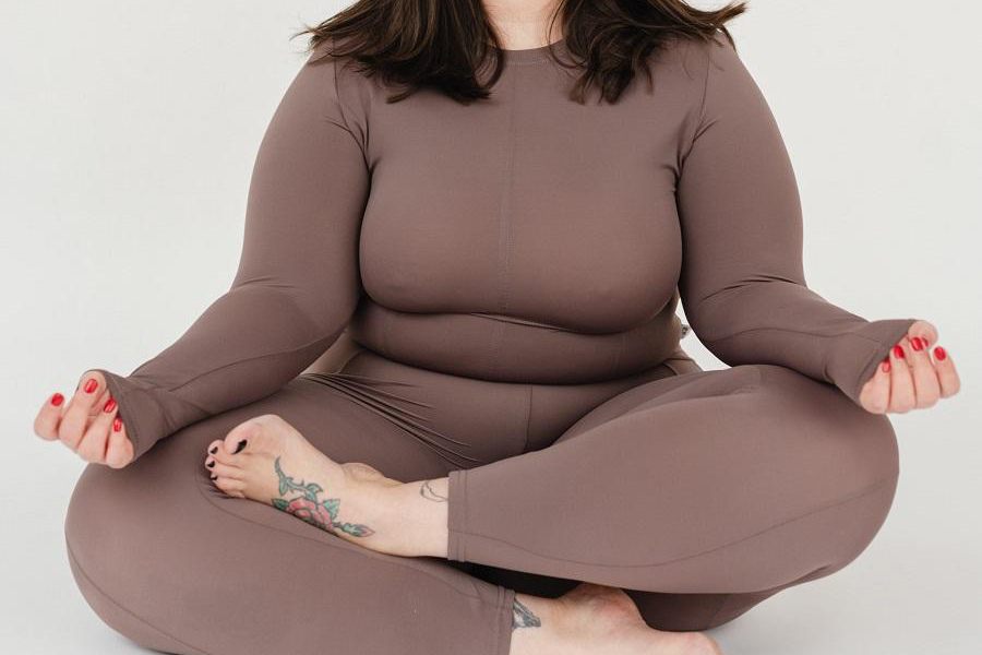 Senhora plus size em um conjunto esportivo marrom claro de 2 peças