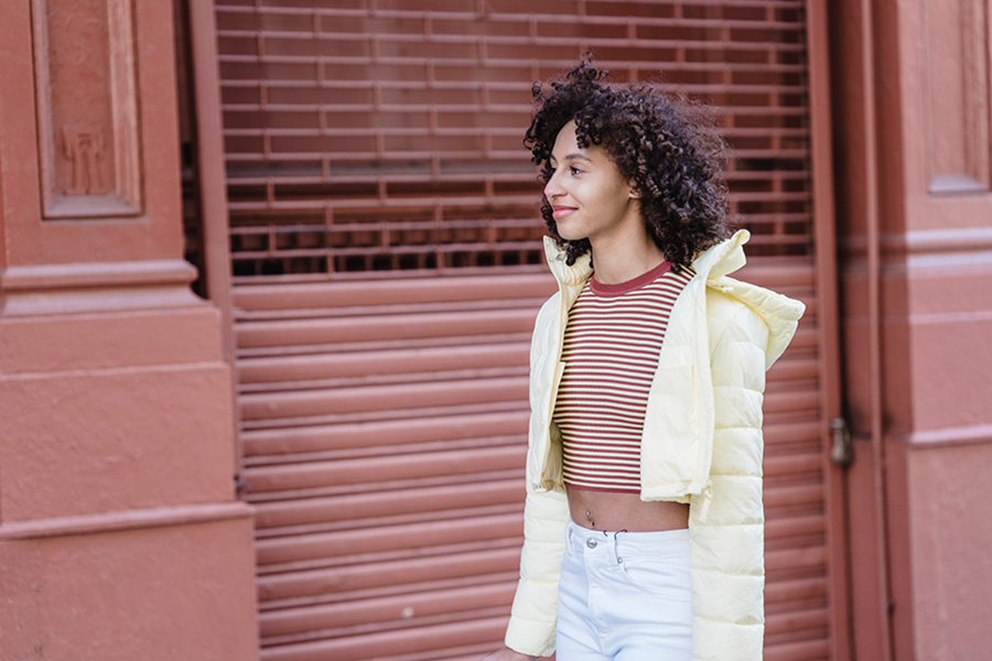 Jeune femme en crop top en couches avec gilet rembourré jaune