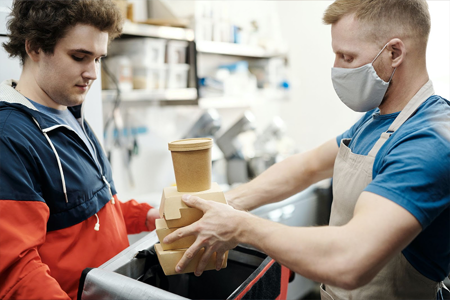 Uomo che mette cibo su una borsa termica