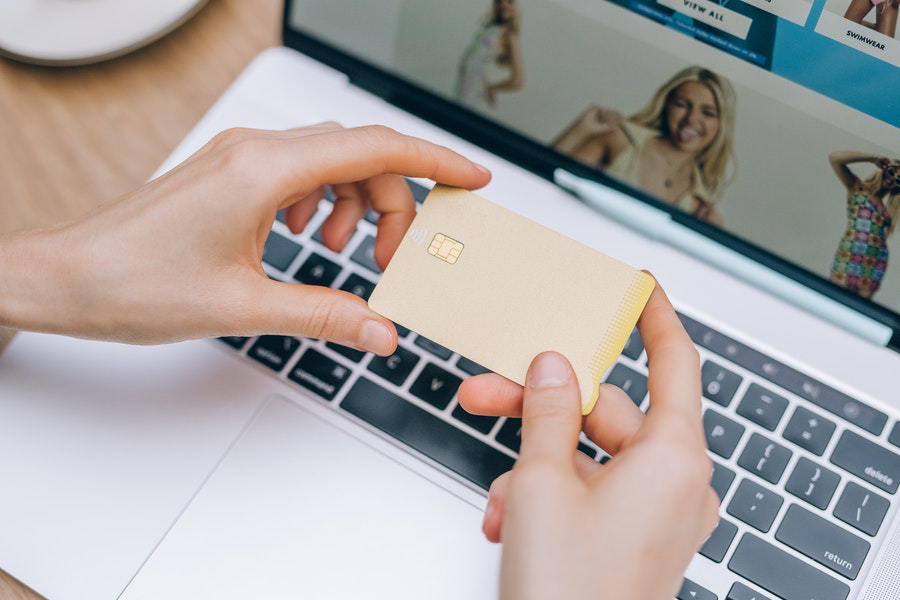 Jovem fazendo compras e fazendo um pagamento com cartão