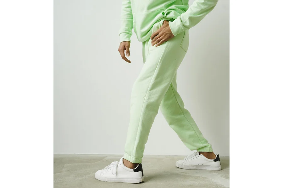 Un uomo che indossa pantaloni da jogging verde chiaro