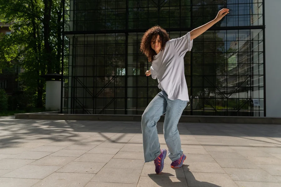 特大のシャツとデニムで踊る黒人女性