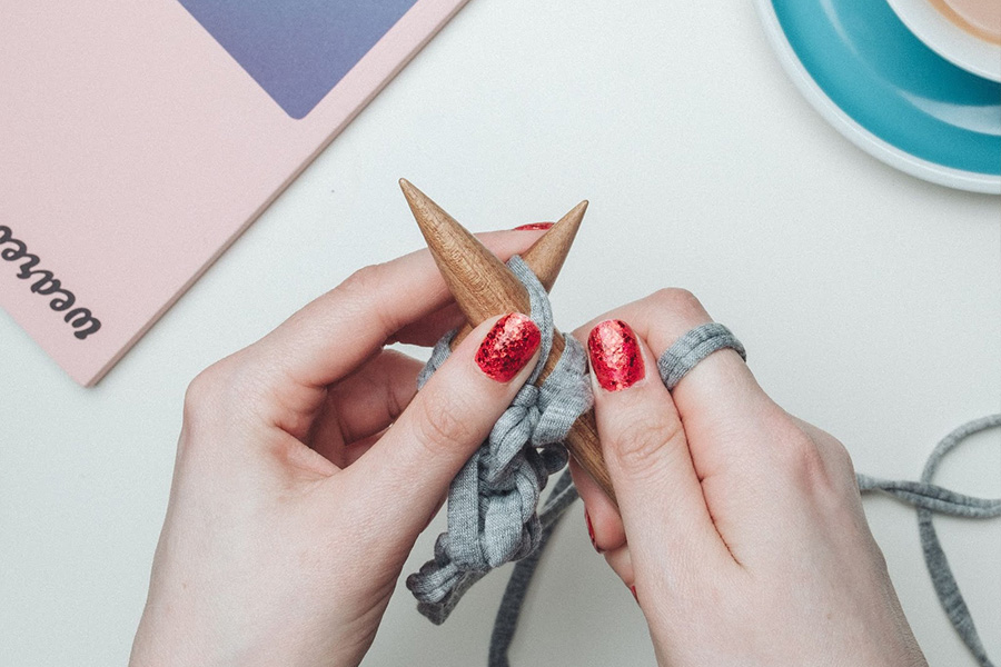 Mains féminines tricotant des produits à publier sur Etsy