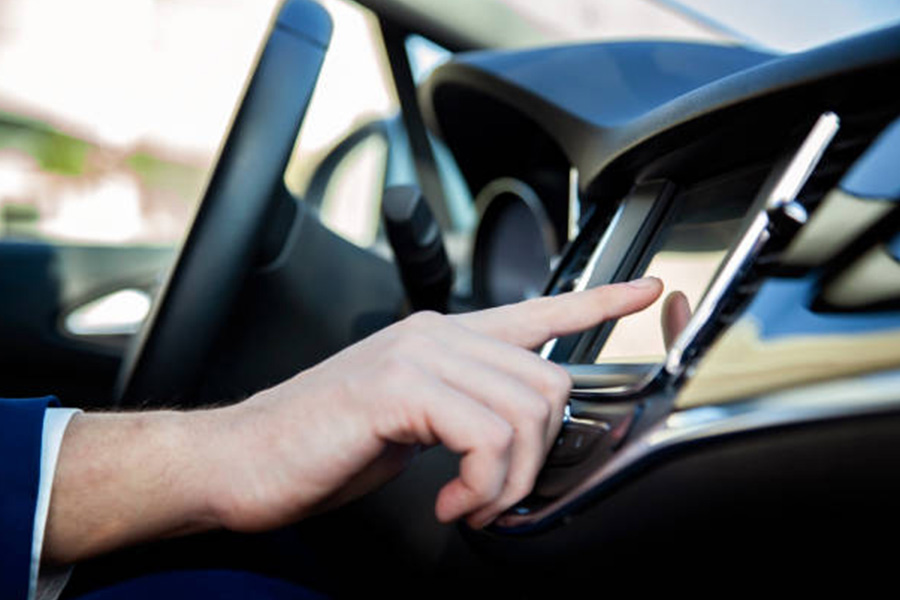 homem usando sistema multimídia embutido em um carro