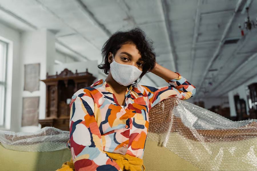 Mulher mascarada com camisa colorida estampada