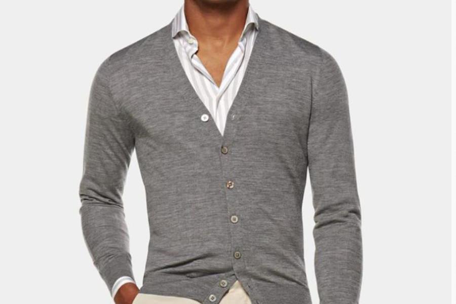 Un uomo che indossa un maglione cardigan grigio