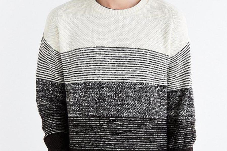 Un uomo che indossa un maglione girocollo monocromatico