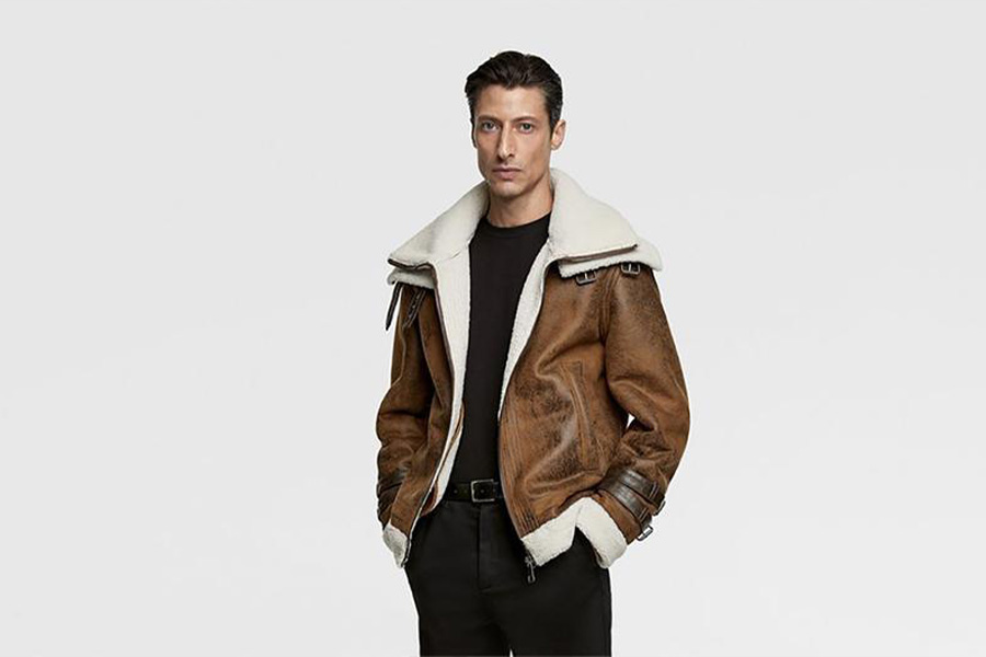 Um homem balançando um casaco marrom de shearling