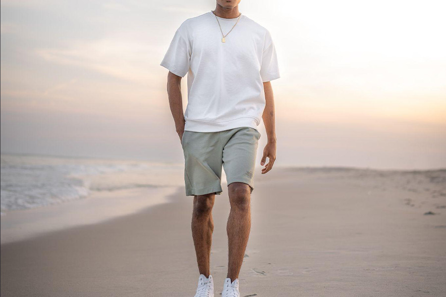 Un homme marchant sur la plage en short