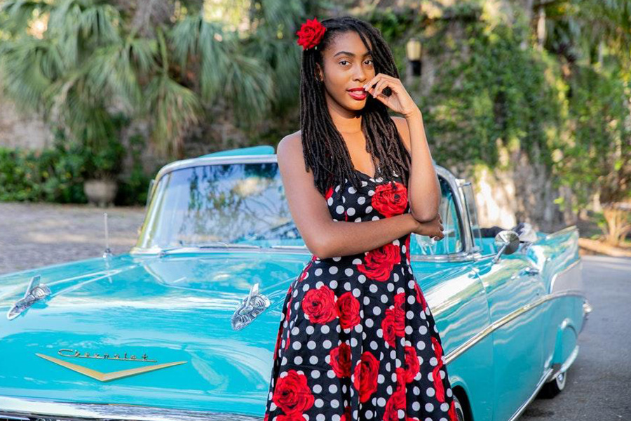 Modelo afroamericano con un vestido floral negro y rojo