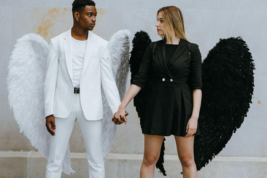 Casal em trajes de anjo contrastantes