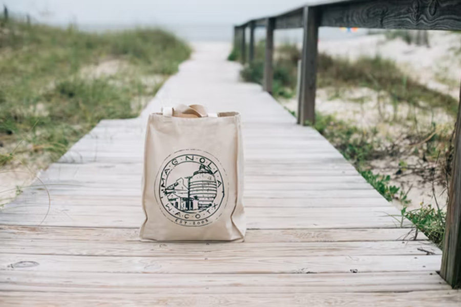 Sac shopping en toile crème sur une promenade à la plage