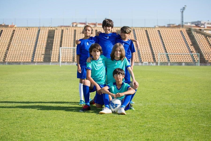 Crianças vestindo camisas em um campo de futebol