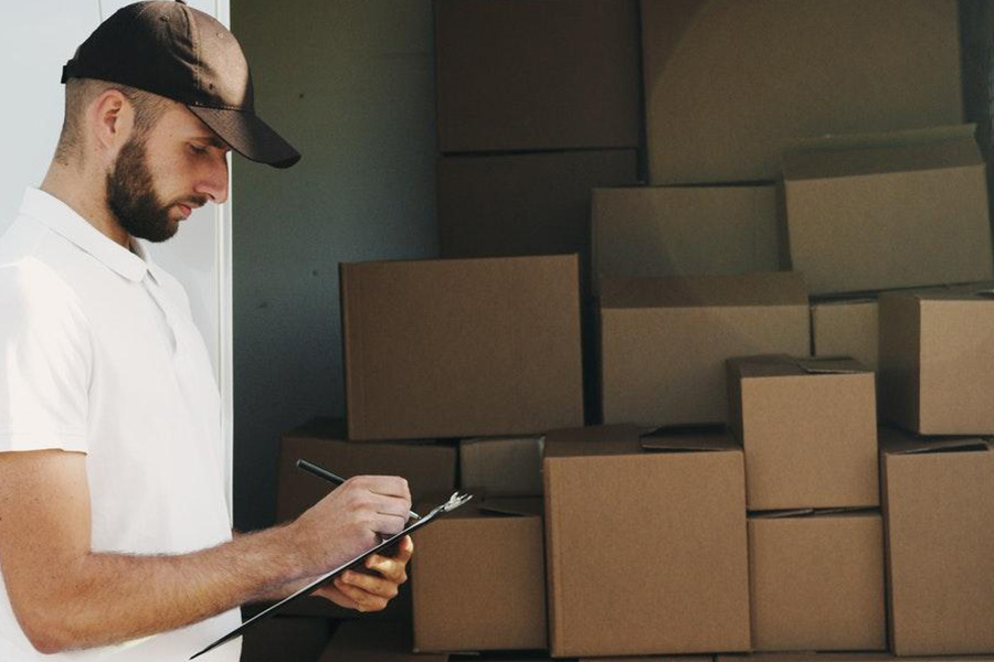 Man in white shirt accounting for stock in a warehouse