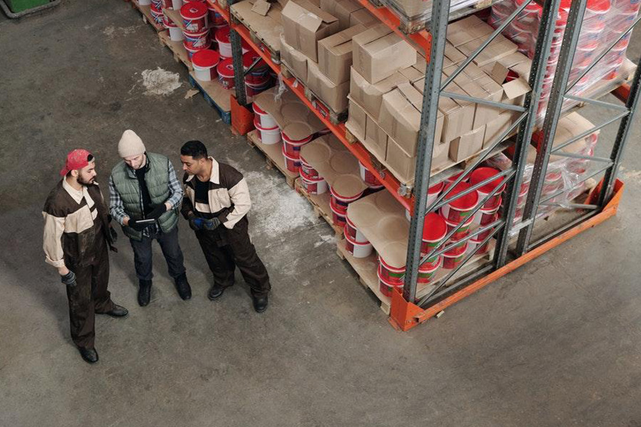 Three men in a warehouse having a discussion