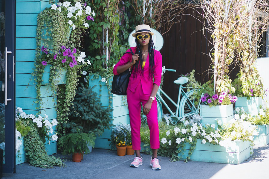 Frau im Retro-Stil mit rosa Anzughose und Leibchen