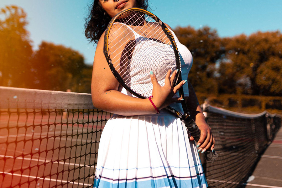 Frau spielt Tennis in Skorts