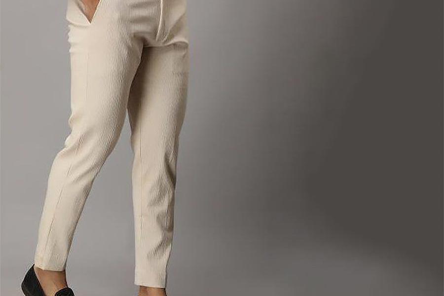 Un uomo che indossa pantaloni affusolati color crema