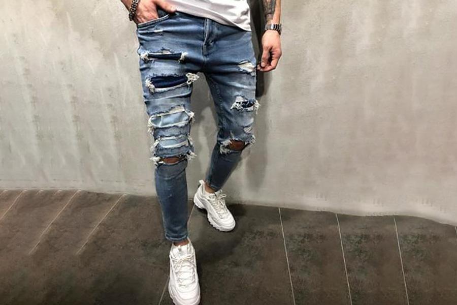 Un uomo che indossa dei jeans strappati