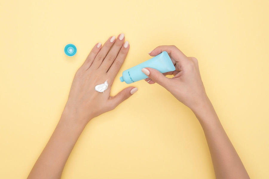 A woman applying cream on her hand