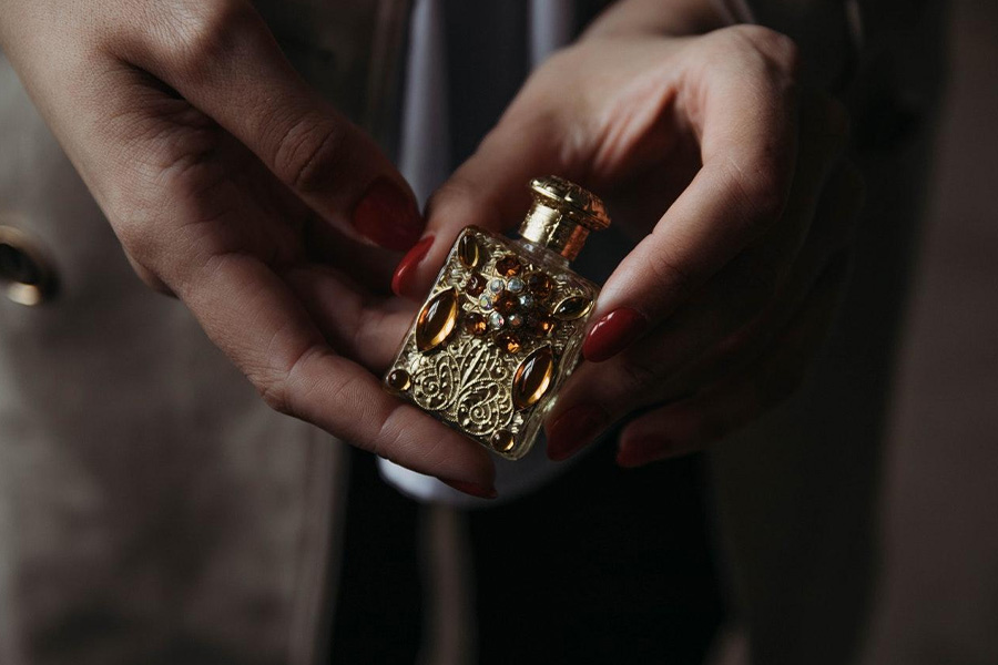 Une femme tenant un parfum incrusté de pierre