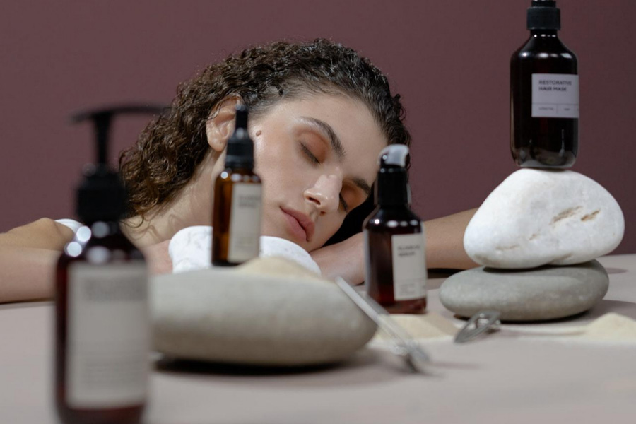 Une femme aux cheveux bouclés et aux produits de soins capillaires