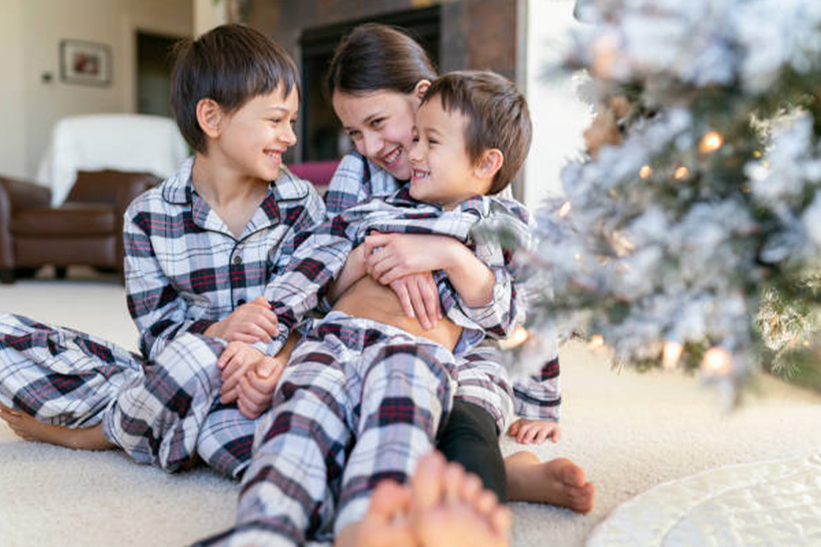 Drei Kinder im passenden Familienpyjama-Set zu Weihnachten