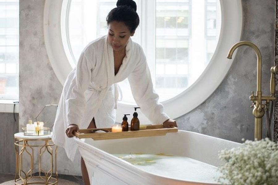 Femme sur le point de prendre un bain avec lumière naturelle