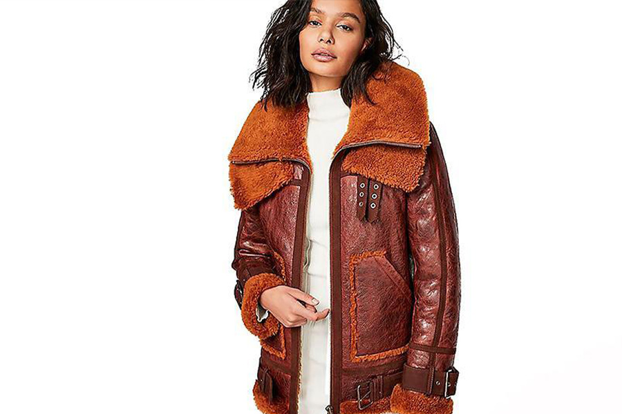 Seorang wanita mengayunkan jaket shearling coklat tua