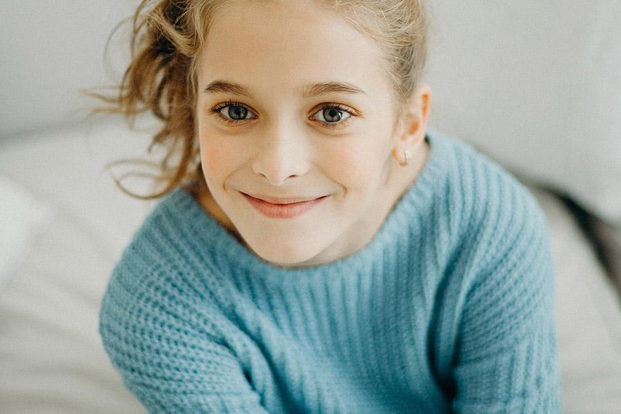 Giovane ragazza che indossa un maglione azzurro