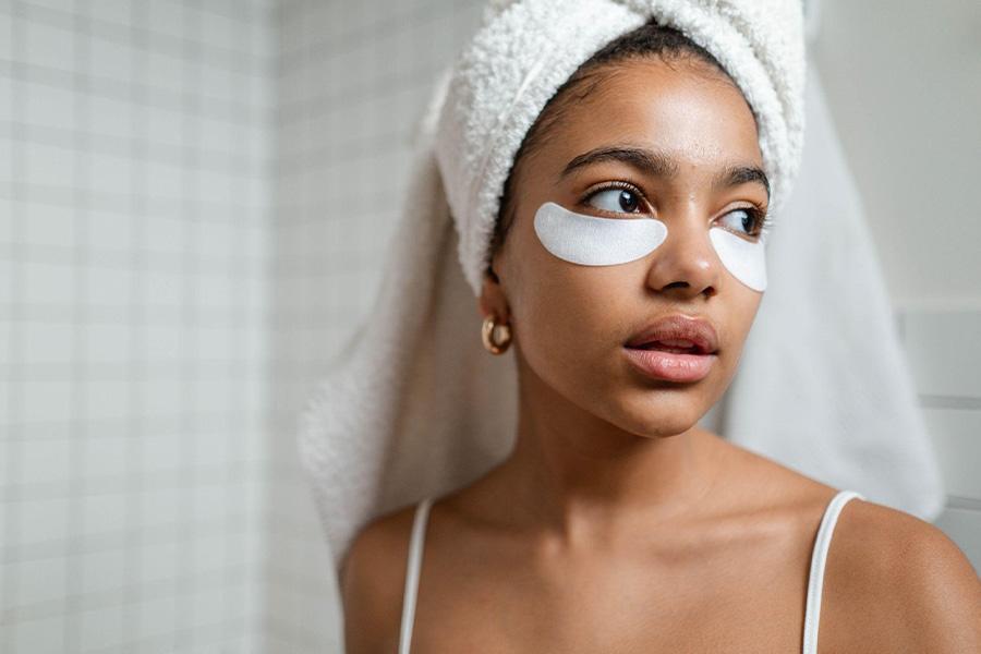 Jovem mulher usando máscaras sob os olhos