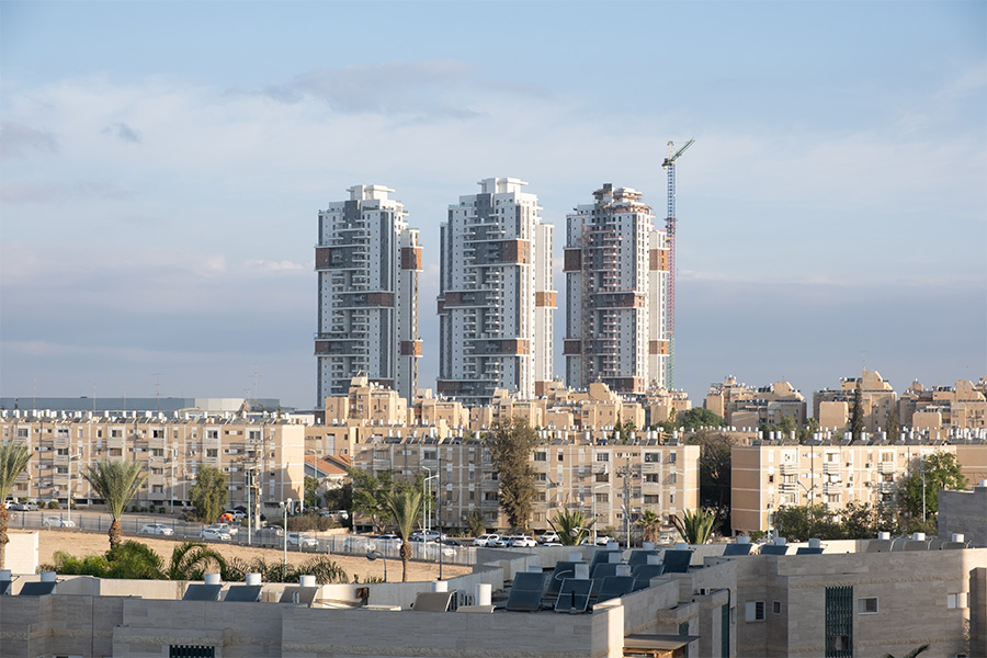 Um lote de aquecedor solar de água no telhado de telhas. Várias gerações de arquitetura de edifícios em Beer Sheba, Israel