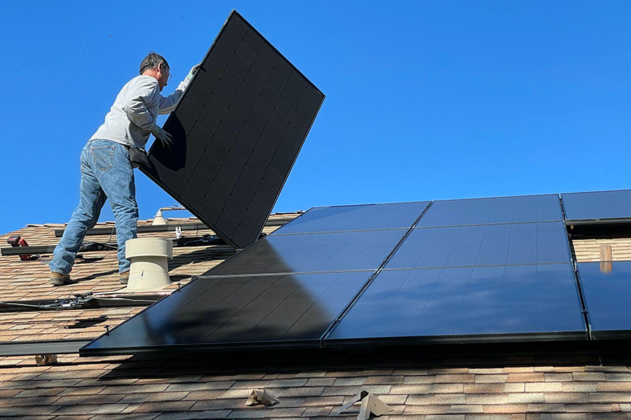 Homem instalando painéis solares em um telhado