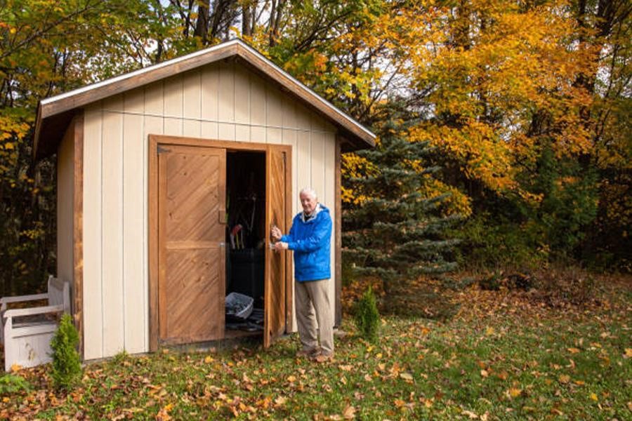 Man opening the door to an outdoor shed