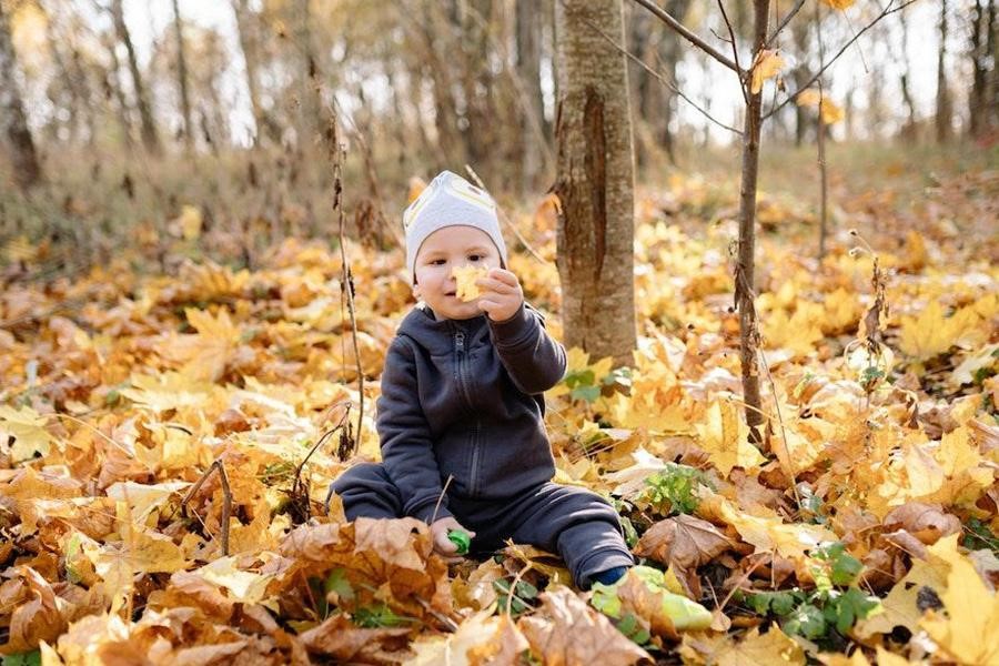 Tout-petit portant une veste noire dans les bois