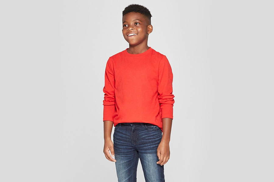 Tween souriant tout en portant un tee-shirt rouge à manches longues