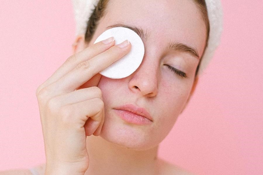 Femme se démaquillant avec un coton réutilisable